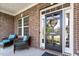 Cozy front porch with seating, stylish front door with sidelights, and attractive brick facade at 1217 Clandon Square Rd, Hillsborough, NC 27278