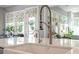 Close-up of a kitchen sink with modern fixtures and a bright window overlooking an outdoor space at 1217 Clandon Square Rd, Hillsborough, NC 27278