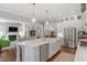 Open kitchen featuring a spacious island, stainless steel appliances, and seamless flow to the living room at 1217 Clandon Square Rd, Hillsborough, NC 27278