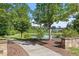 Peaceful view of a pond with a paved walkway, surrounded by trees and landscaping in a residential community at 1217 Clandon Square Rd, Hillsborough, NC 27278