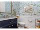Stylish powder room featuring floral wallpaper, marble countertop, and elegant gold fixtures at 1217 Clandon Square Rd, Hillsborough, NC 27278