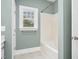 Bathroom featuring a shower-tub combo with tiled walls and a bright window at 1230 Sykes Rd, Spring Hope, NC 27882