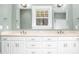 Bright bathroom featuring double sinks, a window view, and ample storage space in white cabinetry at 1230 Sykes Rd, Spring Hope, NC 27882