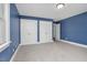 Blue bedroom featuring carpeted floors, trim, windows, and two closets at 1230 Sykes Rd, Spring Hope, NC 27882