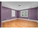 Bedroom featuring hardwood floors, purple walls, and two windows providing natural light at 1230 Sykes Rd, Spring Hope, NC 27882
