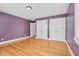 Bedroom features hardwood floors, purple walls, and two closets at 1230 Sykes Rd, Spring Hope, NC 27882