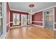 Formal dining room featuring hardwood floors, red walls, white trim, and a crystal chandelier at 1230 Sykes Rd, Spring Hope, NC 27882