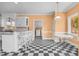 Charming kitchen with black and white checkered floors, breakfast bar, and sunlit dining nook at 1230 Sykes Rd, Spring Hope, NC 27882