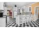 Well-appointed kitchen with white cabinets, breakfast bar, and vintage checkered floors, offering a nostalgic charm at 1230 Sykes Rd, Spring Hope, NC 27882