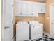 Bright laundry room with white washer and dryer, with additional storage cabinets above the machines at 1230 Sykes Rd, Spring Hope, NC 27882