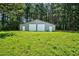 Large outbuilding with two garage doors, offering ample space for storage or workshop on lush green property at 1230 Sykes Rd, Spring Hope, NC 27882