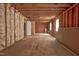 View of a large unfinished room with exposed studs and insulation, ready for customization and renovation at 1230 Sykes Rd, Spring Hope, NC 27882