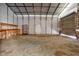 A workshop features a roll up door, shelving, and a workbench, providing a practical space for projects and storage at 1230 Sykes Rd, Spring Hope, NC 27882