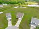 Expansive aerial view showcases lush landscaping, surrounding serene lake, and long driveway at 124 Lahinch Dr, Fuquay Varina, NC 27526