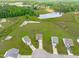 Picturesque aerial view featuring a beautifully landscaped backyard, lake, and long driveway at 124 Lahinch Dr, Fuquay Varina, NC 27526