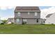 Back exterior of a gray home with a lawn, patio, and solar panels on the roof at 124 Lahinch Dr, Fuquay Varina, NC 27526