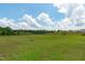 Large, well-maintained backyard with an expansive green lawn and a picturesque view of trees in the distance at 124 Lahinch Dr, Fuquay Varina, NC 27526