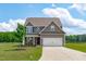 Inviting two-story home featuring a two-car garage, well-manicured lawn, and a charming covered front porch at 124 Lahinch Dr, Fuquay Varina, NC 27526