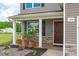 Inviting covered front porch with stone accents and stylish columns, enhanced by potted plants and landscaping at 124 Lahinch Dr, Fuquay Varina, NC 27526