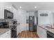 Well-lit kitchen boasts stainless steel refrigerator, granite countertops, and modern backsplash at 124 Lahinch Dr, Fuquay Varina, NC 27526