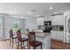 Kitchen island with countertop seating overlooks breakfast nook and is adjacent to well-lit living area at 124 Lahinch Dr, Fuquay Varina, NC 27526
