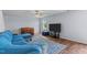 Comfortable living room with plush blue sectional sofa and stylish area rug on wood flooring at 124 Lahinch Dr, Fuquay Varina, NC 27526