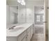 Well-lit bathroom vanity with white cabinets, neutral tile flooring, and access to the bedroom at 127 Cedar Elm Rd, Durham, NC 27713