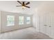 Light-filled bedroom with three windows, neutral carpet, and closet with double doors at 127 Cedar Elm Rd, Durham, NC 27713