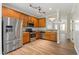 Stylish kitchen with stainless steel appliances, warm wood cabinets, and ample counter space for meal preparation at 127 Cedar Elm Rd, Durham, NC 27713