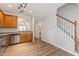 Open kitchen space with stainless steel appliances, warm wooden cabinets, and an adjacent staircase at 127 Cedar Elm Rd, Durham, NC 27713
