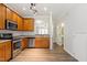 Functional kitchen featuring stainless steel appliances, wooden cabinetry, and a view to the living spaces at 127 Cedar Elm Rd, Durham, NC 27713