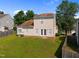 View of backyard featuring a well-maintained lawn and a two-story home at 1308 Snyder St, Durham, NC 27713