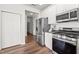 Well-equipped kitchen with stainless steel appliances, white cabinetry, and wood-look flooring at 1308 Snyder St, Durham, NC 27713
