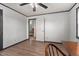 White walled bedroom with paneled accent, dark trim, and wood-look floors and an open doorway to another room at 1308 Tyson Loop Rd, Spring Hope, NC 27882