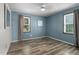 Inviting bedroom with wood-look flooring and blue accent walls, featuring windows that provide natural light at 1308 Tyson Loop Rd, Spring Hope, NC 27882