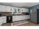 Bright kitchen featuring white cabinets, stainless steel appliances, wood-look floors and a window overlooking the backyard at 1308 Tyson Loop Rd, Spring Hope, NC 27882