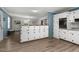 Open kitchen layout showcasing white cabinets, wood-look flooring, and a breakfast bar for casual dining at 1308 Tyson Loop Rd, Spring Hope, NC 27882