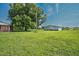 Expansive yard and detached building surrounded by lush greenery under a clear blue sky at 1308 Tyson Loop Rd, Spring Hope, NC 27882