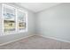 A pair of double-hung windows offer a view to the neighborhood in this carpeted bedroom at 139 His Way, Middlesex, NC 27557