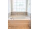 Relaxing bathroom featuring a large soaking tub with tile accents and natural light at 1402 Southpoint Trl, Durham, NC 27713