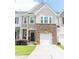 Charming townhome featuring a stone facade, attached garage, and a well-manicured lawn at 1402 Southpoint Trl, Durham, NC 27713
