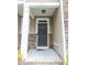 Close-up of the front door with stone detailing, a covered porch, and neutral siding at 1402 Southpoint Trl, Durham, NC 27713