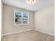 Bedroom features a window with view, neutral walls, carpeted flooring and a ceiling light at 147 Everwood Dr, Four Oaks, NC 27524