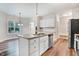 Bright kitchen showcasing an island, stainless steel appliances, granite countertops, and white cabinets at 147 Everwood Dr, Four Oaks, NC 27524