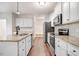 Modern kitchen featuring white cabinets, granite countertops, and stainless steel appliances at 147 Everwood Dr, Four Oaks, NC 27524