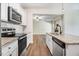 Open kitchen featuring stainless steel appliances and an island with a sink, opening up to the living room at 147 Everwood Dr, Four Oaks, NC 27524