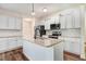 Bright kitchen features granite countertops, white cabinets, stainless steel appliances, and a center island at 147 Everwood Dr, Four Oaks, NC 27524