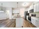 Well-appointed kitchen featuring an island, granite counters, white cabinetry, and modern appliances at 147 Everwood Dr, Four Oaks, NC 27524