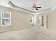 Large main bedroom with carpet, large windows, a ceiling fan, and access to the main bathroom at 147 Everwood Dr, Four Oaks, NC 27524