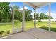 Screened-in porch view of large grassy backyard with playground at 147 Everwood Dr, Four Oaks, NC 27524